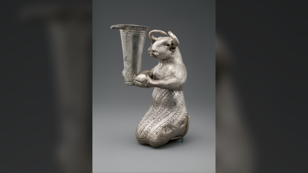 silver human-like bull holding a vessel